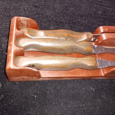 A SET OF CUTCO KITCHEN UTENSILS IN A WALL HUNG HOLDER