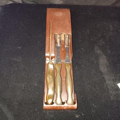 A SET OF CUTCO KITCHEN UTENSILS IN A WALL HUNG HOLDER