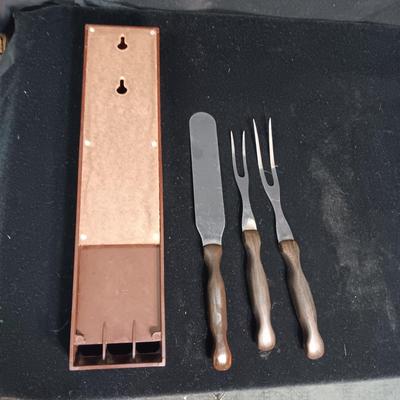A SET OF CUTCO KITCHEN UTENSILS IN A WALL HUNG HOLDER