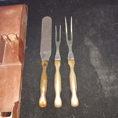 A SET OF CUTCO KITCHEN UTENSILS IN A WALL HUNG HOLDER