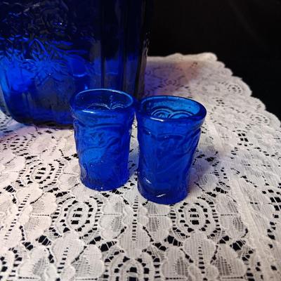 COBALT BLUE GLASS CANISTER W/LID, SMALL PITCHER AND 2 GLASS CUPS WITH RAISED BIRD DESIGN