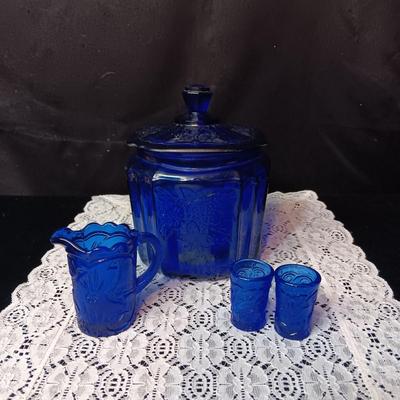 COBALT BLUE GLASS CANISTER W/LID, SMALL PITCHER AND 2 GLASS CUPS WITH RAISED BIRD DESIGN