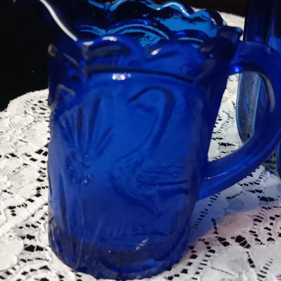 COBALT BLUE GLASS CANISTER W/LID, SMALL PITCHER AND 2 GLASS CUPS WITH RAISED BIRD DESIGN