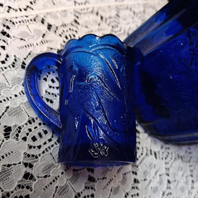 COBALT BLUE GLASS CANISTER W/LID, SMALL PITCHER AND 2 GLASS CUPS WITH RAISED BIRD DESIGN