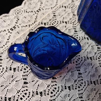 COBALT BLUE GLASS CANISTER W/LID, SMALL PITCHER AND 2 GLASS CUPS WITH RAISED BIRD DESIGN
