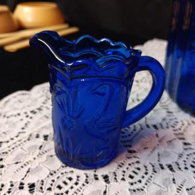 COBALT BLUE GLASS CANISTER W/LID, SMALL PITCHER AND 2 GLASS CUPS WITH RAISED BIRD DESIGN