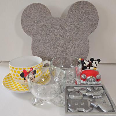LOT 124B: Mickey Mouse Head Shaped Cutting Board, Metal Trivet, Bowls with Mickey's Feet, Minnie Mouse Cup and Saucer, and Minnie...