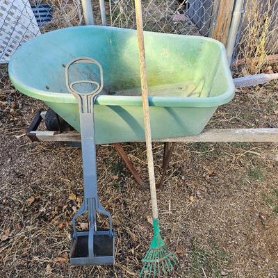 Large sized plastic wheelbarrow with a poop scooper and small rake