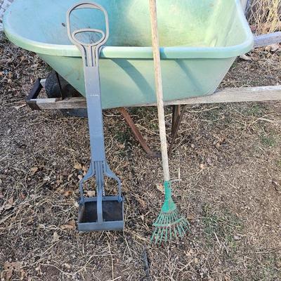 Large sized plastic wheelbarrow with a poop scooper and small rake