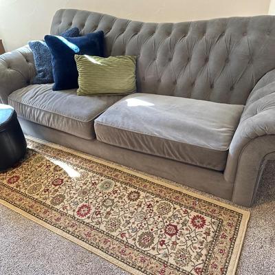 Gray velveteen sofa- tufted back , rug, footstool