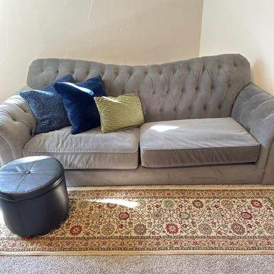 Gray velveteen sofa- tufted back , rug, footstool