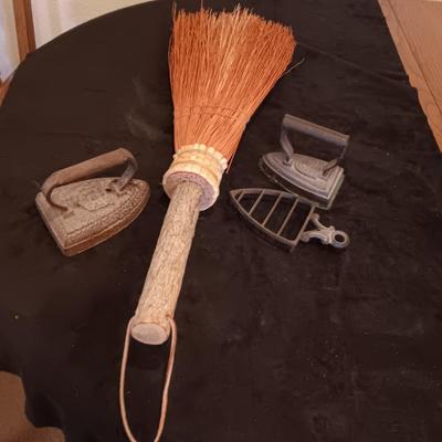 2 VINTAGE CAST IRONS AND A HANDCRAFTED BROOM