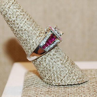 Size 7 ½ RUBY RED Border & Accents Surrounding a Clear Round Stone Ring on a Silver Tone Band (5.6g)