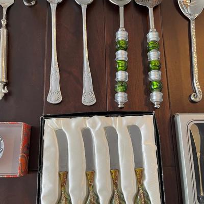 Lot of salad servers, cocktail skewers and cheese knives