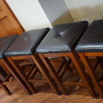 SET OF FOUR VERY HANDY SNACK BAR STOOLS W/ FAUX BLACK LEATHER UPHOLSTERED PADS. WOOD FRAME