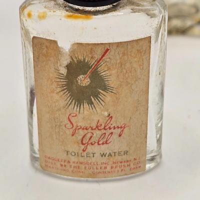 LOT 542: Antique Perfume Bottles, Talc Bottles, Ladies Handkerchiefs, Makeup , Greeting Cards, Face Cream, Face Fan, & Small Bud Vase