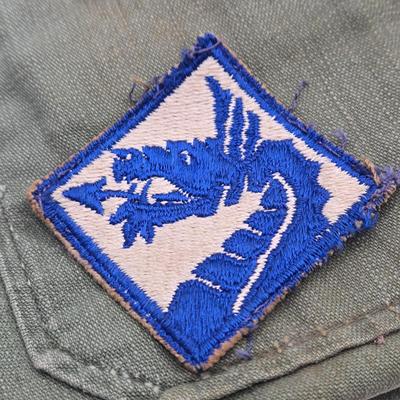 LOT 556: Army Jacket, Multiple Patches, Notice of Recruitment, Metal Pins, Cannon, & Charm, Postcard, & First Aid smelling Salts