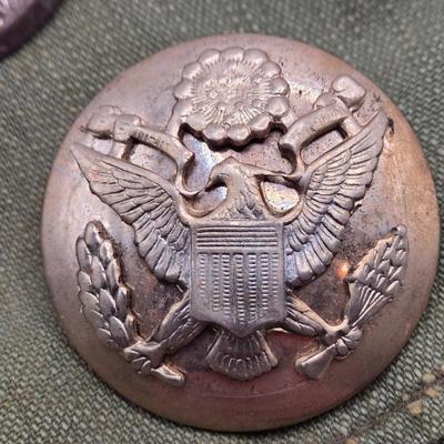 LOT 556: Army Jacket, Multiple Patches, Notice of Recruitment, Metal Pins, Cannon, & Charm, Postcard, & First Aid smelling Salts
