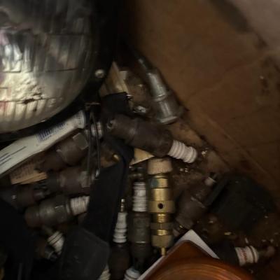 Box of vintage lights with spark plugs at the bottom of the box
