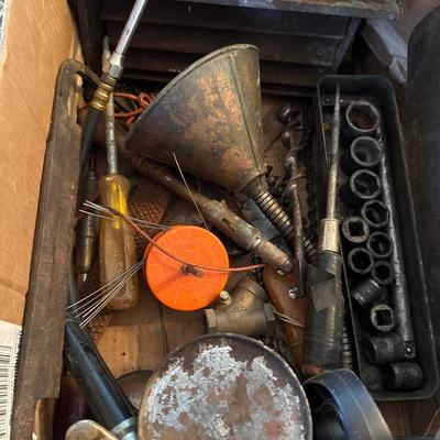 Box full of oil, oil funnel, tools and knives