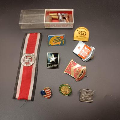 VARIOUS PINS INCLUDING A SWASTIKA AND SOME FIRED BULLETS??