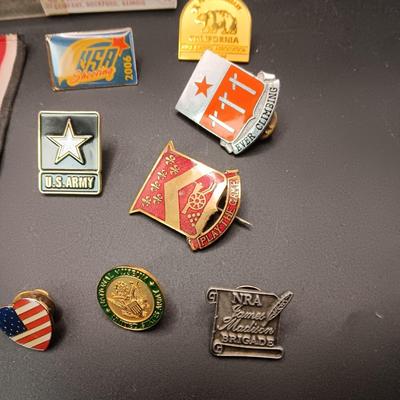 VARIOUS PINS INCLUDING A SWASTIKA AND SOME FIRED BULLETS??