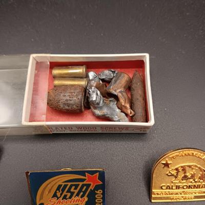 VARIOUS PINS INCLUDING A SWASTIKA AND SOME FIRED BULLETS??