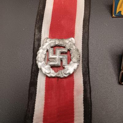 VARIOUS PINS INCLUDING A SWASTIKA AND SOME FIRED BULLETS??