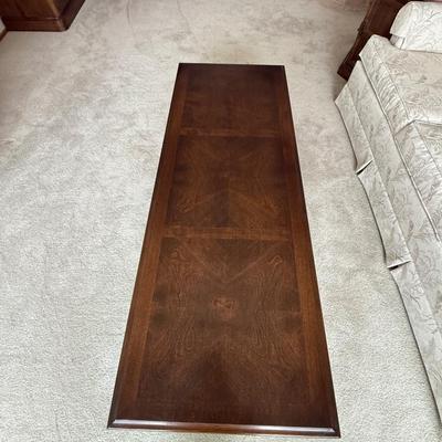 Sale Photo Thumbnail #16: The Ethan Allen coffee table is a vintage-style piece designed for the living room. It features a rectangular shape and is crafted from solid wood with a dark finish. Measuring 60 inches in length, 22.5 inches in width, and 16 inches in height, this table