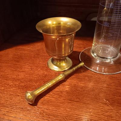 NEEDLEPOINT PHARMACY PICTURE, TALL GLASS BEEKER AND BRASS PESTLE & MORTAR