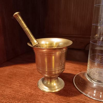 NEEDLEPOINT PHARMACY PICTURE, TALL GLASS BEEKER AND BRASS PESTLE & MORTAR