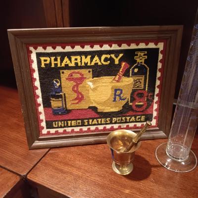NEEDLEPOINT PHARMACY PICTURE, TALL GLASS BEEKER AND BRASS PESTLE & MORTAR