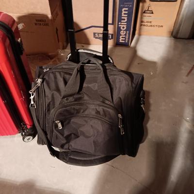 LIKE NEW RED CARRY ON WITH 4 WHEELS AND DUFFLE BAG ON 2 WHEELS