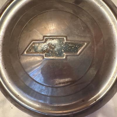 The object pictured is a Chevrolet "Dog Dish" hubcap, likely from the model years 1951-1953.