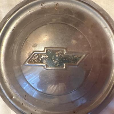 The object pictured is a Chevrolet "Dog Dish" hubcap, likely from the model years 1951-1953.