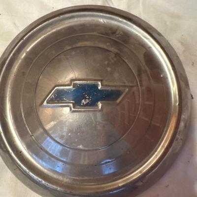The object pictured is a Chevrolet "Dog Dish" hubcap, likely from the model years 1951-1953.
