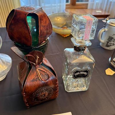 2 different liquor decanters 1 wrapped in leather