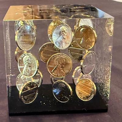 Acrylic cube with shiny pennies floating inside