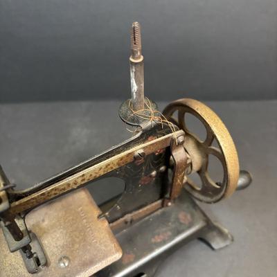 LOT 88: Antique Toy Sewing Machine Made in Germany, Sewing Notions & Button Shelf Sitter Doll