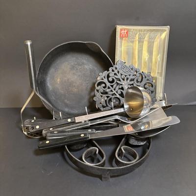 LOT 99: Unmarked Cast Iron Skillet, Zwilling Steak Knife Set, Trivets & Flint Stainless Steel Hanging Kitchen Utensil Set