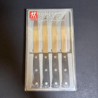 LOT 99: Unmarked Cast Iron Skillet, Zwilling Steak Knife Set, Trivets & Flint Stainless Steel Hanging Kitchen Utensil Set