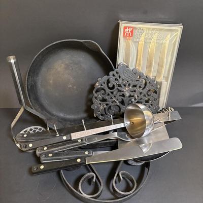 LOT 99: Unmarked Cast Iron Skillet, Zwilling Steak Knife Set, Trivets & Flint Stainless Steel Hanging Kitchen Utensil Set