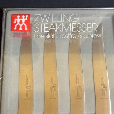 LOT 99: Unmarked Cast Iron Skillet, Zwilling Steak Knife Set, Trivets & Flint Stainless Steel Hanging Kitchen Utensil Set