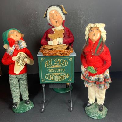 LOT 114: Set of 3 Byers' Choice Carolers - Two (2) Children From 1982 with Signed Bases and a Ginger Bread Seller and Stand from 1996