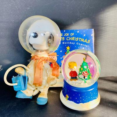 LOT 134: Vintage Peanuts Snoopy Astronaut from 1969 and 50th Anniversary Peanut Holiday Book and Snow Globe