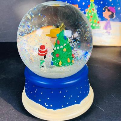 LOT 134: Vintage Peanuts Snoopy Astronaut from 1969 and 50th Anniversary Peanut Holiday Book and Snow Globe