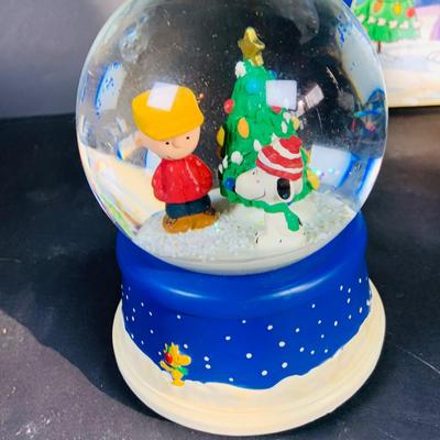 LOT 134: Vintage Peanuts Snoopy Astronaut from 1969 and 50th Anniversary Peanut Holiday Book and Snow Globe