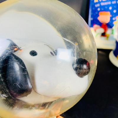 LOT 134: Vintage Peanuts Snoopy Astronaut from 1969 and 50th Anniversary Peanut Holiday Book and Snow Globe