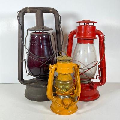 LOT 138: Three Oil Lanterns - Dietz (Gray) and Winged Wheel Brand (Red and Yellow)