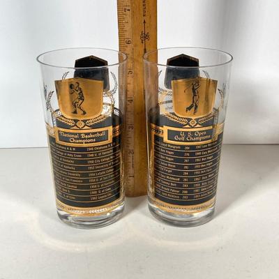 LOT 144: Seven MCM Sports Black and Gold Drinking Glasses / Barware